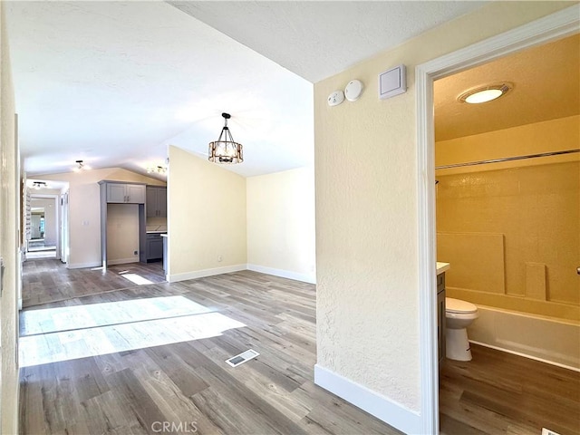 1639 Winn Ct, Pomona, CA 91768 - unfurnished living room featuring vaulted ceiling, light wood-type flooring, and a chandelier