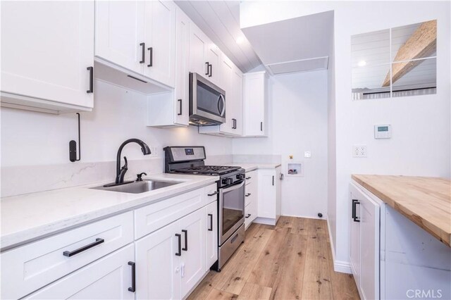 24302 Vista Ridge Dr, Valencia, CA 91355 - kitchen featuring appliances with stainless steel finishes, light wood-style floors, white cabinets, and wooden counters