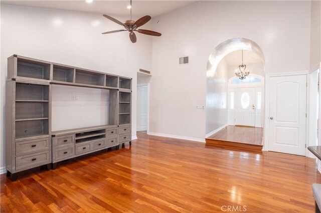 24302 Vista Ridge Dr, Valencia, CA 91355 - unfurnished living room featuring high vaulted ceiling, arched walkways, wood finished floors, ceiling fan, and a chandelier