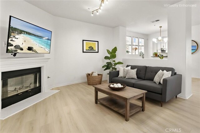 305 W Duarte Rd Unit G, Monrovia, CA 91016 - living room with wood finished floors, a glass covered fireplace, and a chandelier