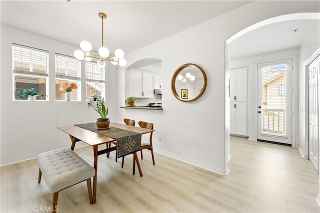 305 W Duarte Rd Unit G, Monrovia, CA 91016 - dining space with arched walkways, light wood finished floors, and a chandelier
