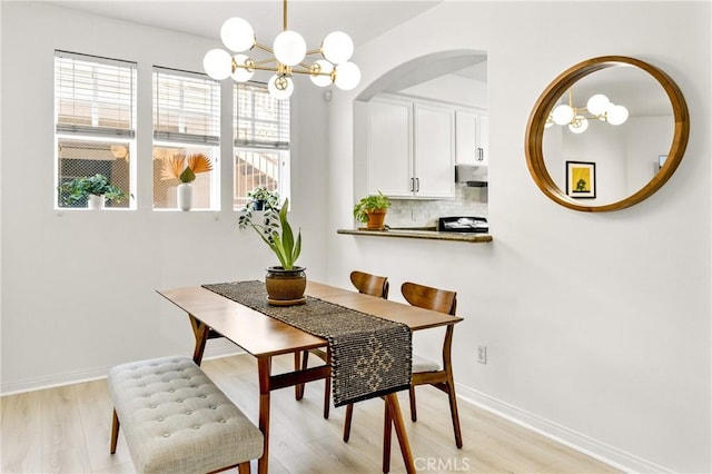 305 W Duarte Rd Unit G, Monrovia, CA 91016 - dining space with light wood-style floors, a chandelier, and arched walkways