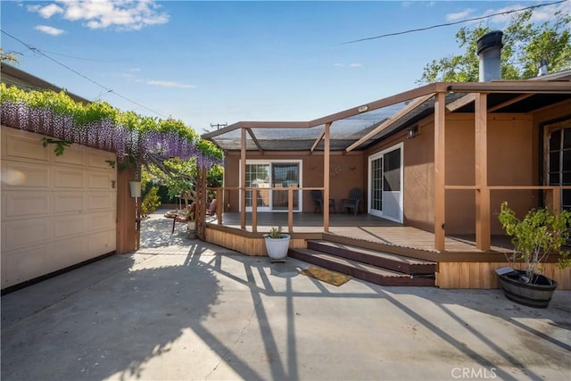 7028 E Parkcrest St, Long Beach, CA 90808 - rear view of property with a wooden deck, a garage, and stucco siding