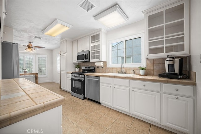 7028 E Parkcrest St, Long Beach, CA 90808 - kitchen with appliances with stainless steel finishes, healthy amount of natural light, light tile patterned flooring, and decorative backsplash