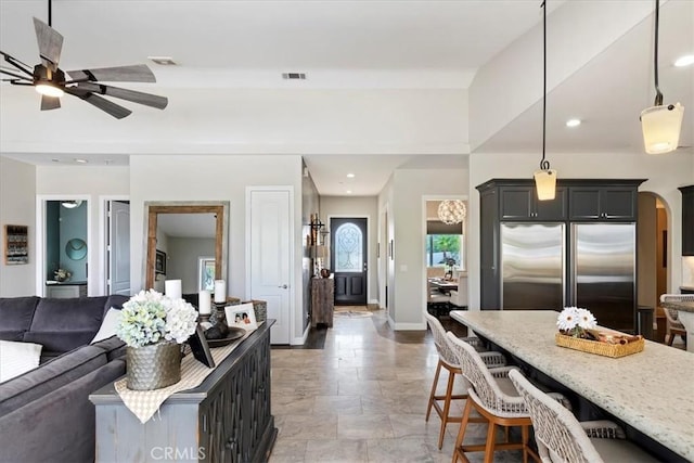 17180 Mockingbird Canyon Rd, Riverside, CA 92504 - living room featuring stone finish flooring, a ceiling fan, recessed lighting, and arched walkways