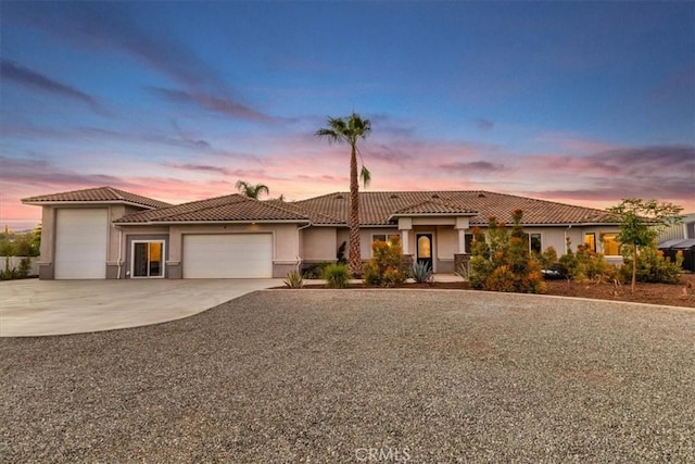 17180 Mockingbird Canyon Rd, Riverside, CA 92504 - mediterranean / spanish-style home featuring an attached garage, a tile roof, stucco siding, and driveway