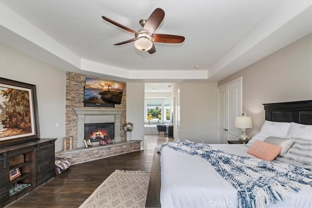 17180 Mockingbird Canyon Rd, Riverside, CA 92504 - bedroom featuring a raised ceiling, a fireplace, wood finished floors, ceiling fan, and connected bathroom
