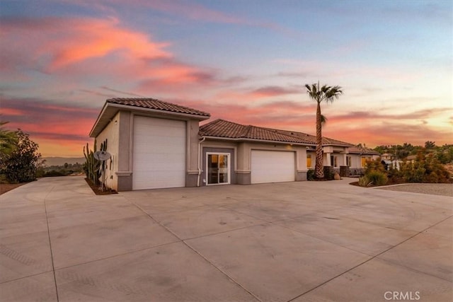 17180 Mockingbird Canyon Rd, Riverside, CA 92504 - mediterranean / spanish-style house featuring a tiled roof, a garage, stucco siding, and concrete driveway