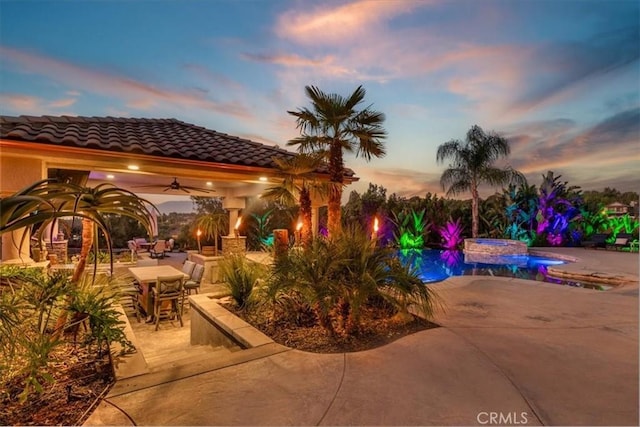 17180 Mockingbird Canyon Rd, Riverside, CA 92504 - patio terrace at dusk featuring a patio area, a ceiling fan, a pool with connected hot tub, and outdoor dining space