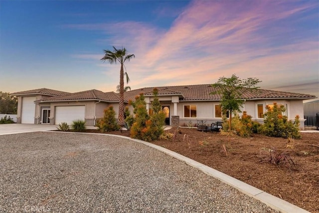 17180 Mockingbird Canyon Rd, Riverside, CA 92504 - view of front of home with driveway, a garage, a tile roof, and stucco siding