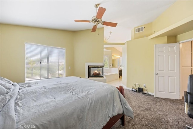 566 Bruin Dr, Riverside, CA 92507 - carpeted bedroom with a multi sided fireplace, vaulted ceiling, ensuite bathroom, and ceiling fan