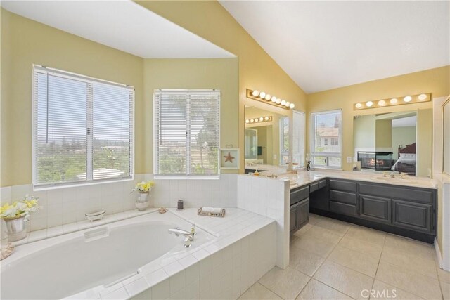 566 Bruin Dr, Riverside, CA 92507 - ensuite bathroom featuring a bath, vaulted ceiling, vanity, and tile patterned floors