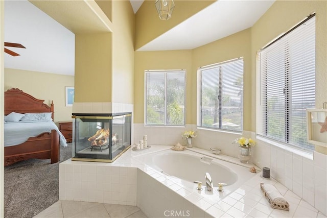 566 Bruin Dr, Riverside, CA 92507 - ensuite bathroom featuring a bath, a multi sided fireplace, ceiling fan, and tile patterned floors