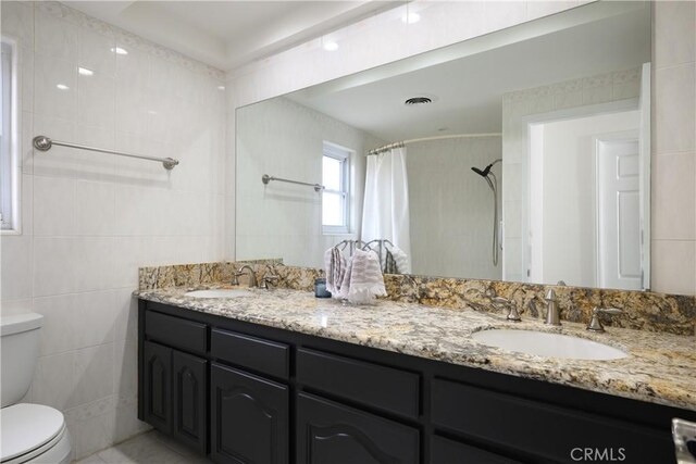5302 Bryant Cir, Westminster, CA 92683 - bathroom with double vanity, tile walls, and curtained shower