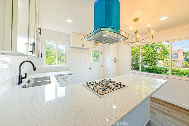 1510 W 147th St, Gardena, CA 90247 - kitchen with island range hood, gas stovetop, light stone counters, white cabinetry, and a chandelier