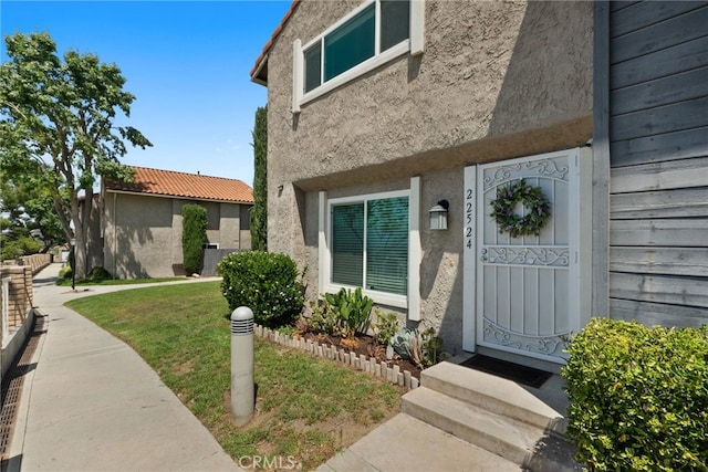 22524 Paseo Terraza, Saugus, CA 91350 - doorway to property featuring stucco siding and a yard