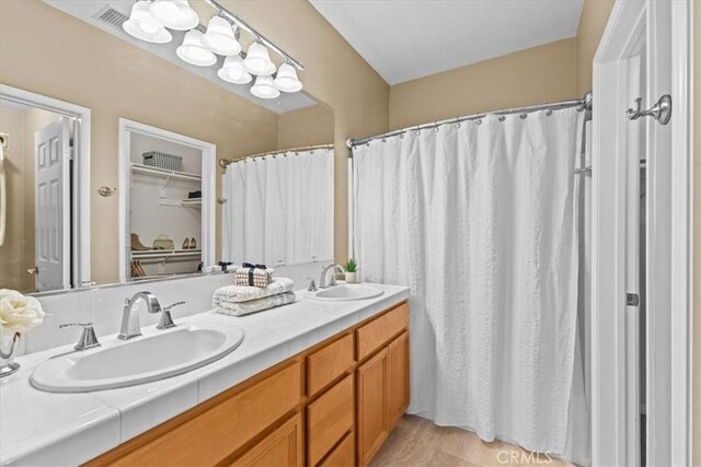 74 Garrison Loop, Ladera Ranch, CA 92694 - bathroom with double vanity, a shower with curtain, and a spacious closet