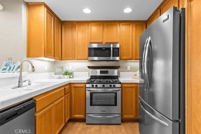 74 Garrison Loop, Ladera Ranch, CA 92694 - kitchen with stainless steel appliances, light wood-type flooring, brown cabinetry, and recessed lighting