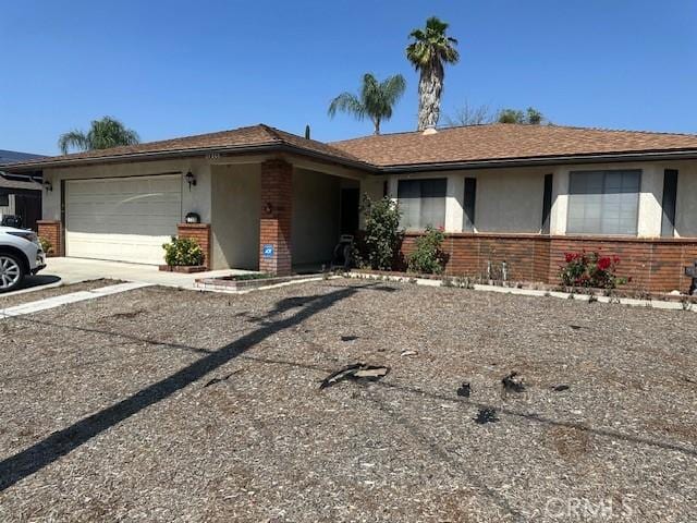 27208 Cornell St, Hemet, CA 92544 - ranch-style home with brick siding, an attached garage, concrete driveway, and stucco siding