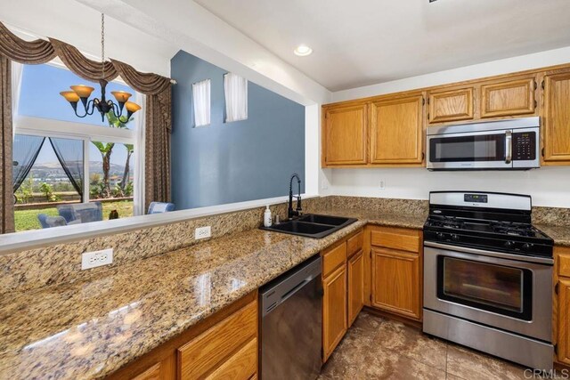 4722 Regatta Ln, San Diego, CA 92154 - kitchen featuring stainless steel appliances, brown cabinetry, a chandelier, and light stone counters