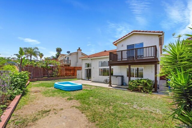4722 Regatta Ln, San Diego, CA 92154 - back of property featuring stucco siding, a balcony, a fenced backyard, a tile roof, and a patio area
