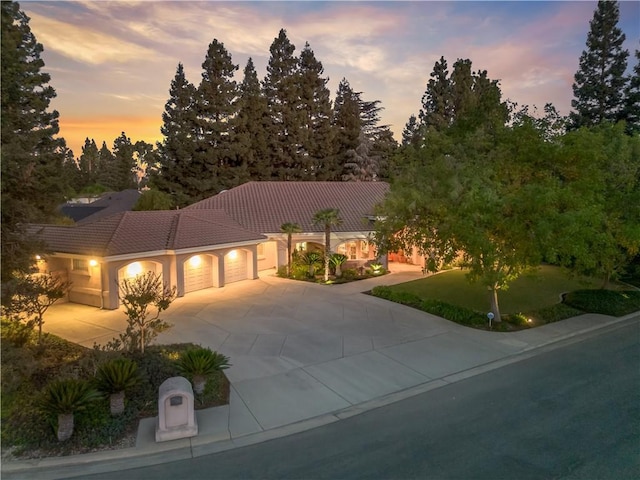 6660 N St Catherine Ct, Fresno, CA 93711 - view of front of property with a garage, driveway, a tiled roof, and stucco siding