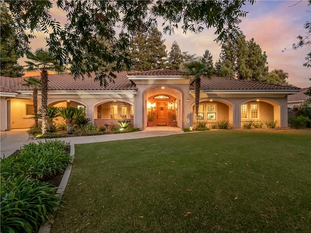 6660 N St Catherine Ct, Fresno, CA 93711 - mediterranean / spanish home featuring stucco siding, a front lawn, a tiled roof, and curved driveway