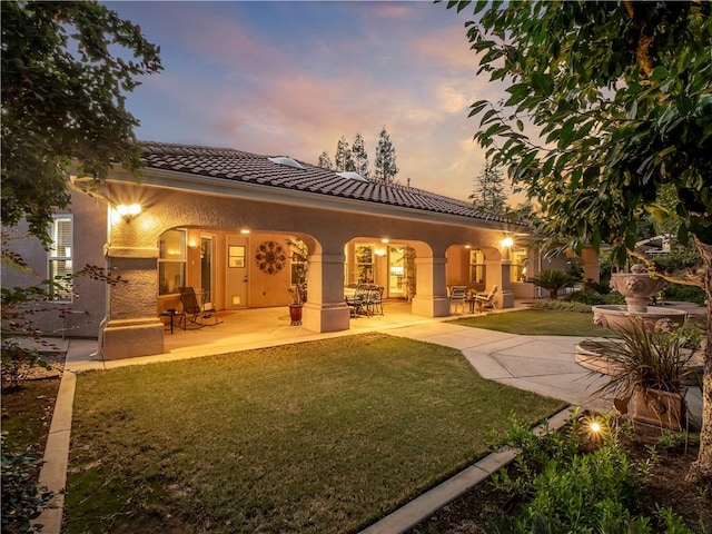 6660 N St Catherine Ct, Fresno, CA 93711 - rear view of property featuring a tile roof, a yard, stucco siding, and a patio