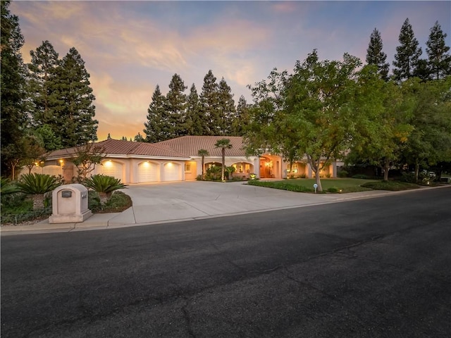 6660 N St Catherine Ct, Fresno, CA 93711 - view of front of house with a tile roof, an attached garage, driveway, and stucco siding