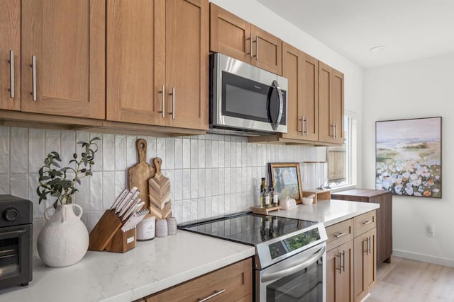 2210 Bonita Ct, Lemon Grove, CA 91945 - kitchen with stainless steel appliances, brown cabinets, decorative backsplash, and light wood-type flooring