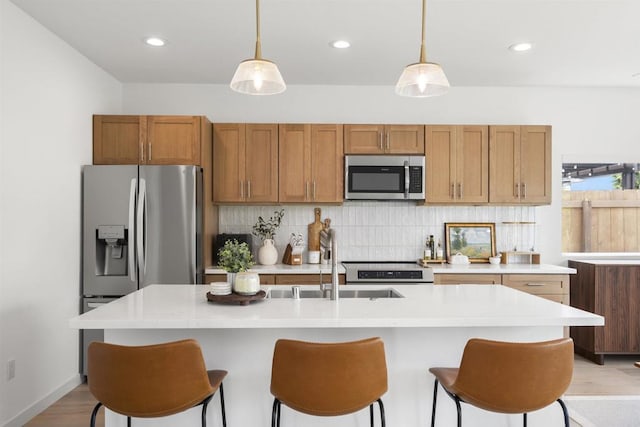 2210 Bonita Ct, Lemon Grove, CA 91945 - kitchen with stainless steel appliances, light countertops, decorative backsplash, brown cabinets, and a kitchen breakfast bar