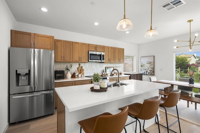 2210 Bonita Ct, Lemon Grove, CA 91945 - kitchen with appliances with stainless steel finishes, light wood-type flooring, decorative backsplash, decorative light fixtures, and recessed lighting
