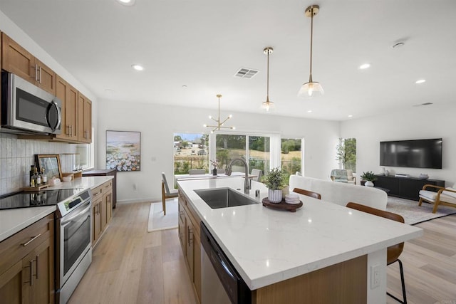 2210 Bonita Ct, Lemon Grove, CA 91945 - kitchen with appliances with stainless steel finishes, light wood finished floors, backsplash, recessed lighting, and a kitchen island with sink