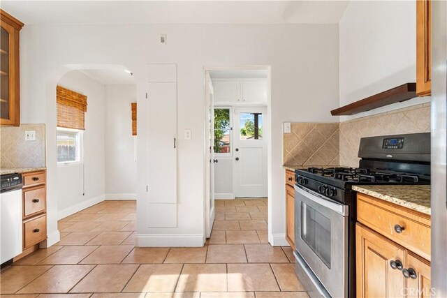 3007 Park Way, Bakersfield, CA 93304 - kitchen with stainless steel gas range, dishwasher, backsplash, arched walkways, and light tile patterned floors