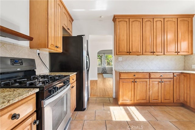 3007 Park Way, Bakersfield, CA 93304 - kitchen featuring stainless steel gas range, arched walkways, light stone countertops, and backsplash
