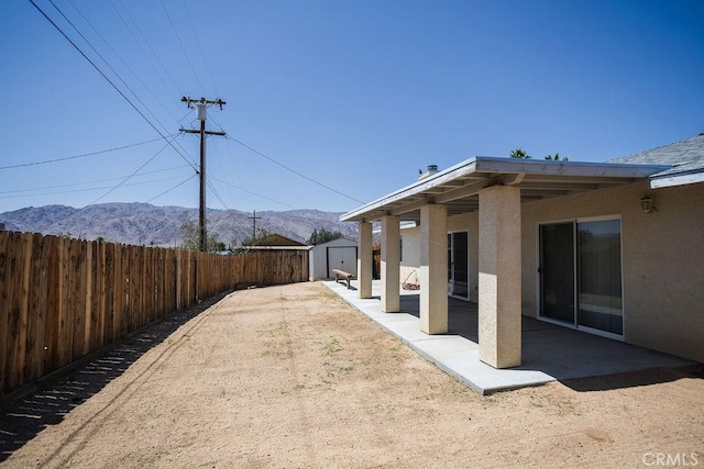 6025 Abronia Ave Unit 29, Palms, CA 92277 - fenced backyard with a storage shed, a mountain view, and a patio area