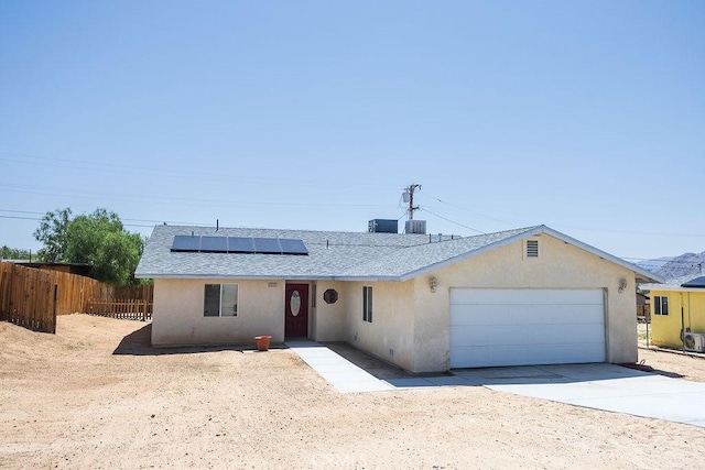 6025 Abronia Ave Unit 29, Palms, CA 92277 - ranch-style home with an attached garage, roof mounted solar panels, stucco siding, driveway, and roof with shingles