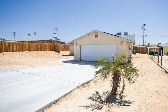 6025 Abronia Ave Unit 29, Palms, CA 92277 - view of front of property featuring concrete driveway, an attached garage, and stucco siding