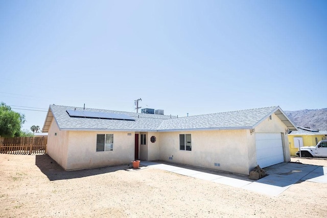 6025 Abronia Ave Unit 29, Palms, CA 92277 - ranch-style house with roof mounted solar panels, stucco siding, a garage, roof with shingles, and a mountain view