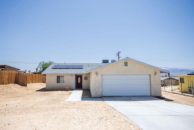 6025 Abronia Ave Unit 29, Palms, CA 92277 - single story home with an attached garage, solar panels, stucco siding, driveway, and roof with shingles