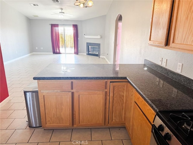 6025 Abronia Ave Unit 29, Palms, CA 92277 - kitchen featuring a peninsula, arched walkways, light tile patterned flooring, and open floor plan