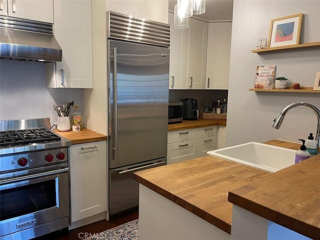 3641 S Bear St Unit F, Santa Ana, CA 92704 - kitchen featuring wooden counters, premium appliances, ventilation hood, and white cabinets