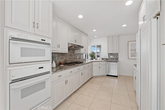 32512 Seven Seas Dr, Dana Point, CA 92629 - kitchen with stainless steel appliances, backsplash, white cabinets, light tile patterned floors, and under cabinet range hood