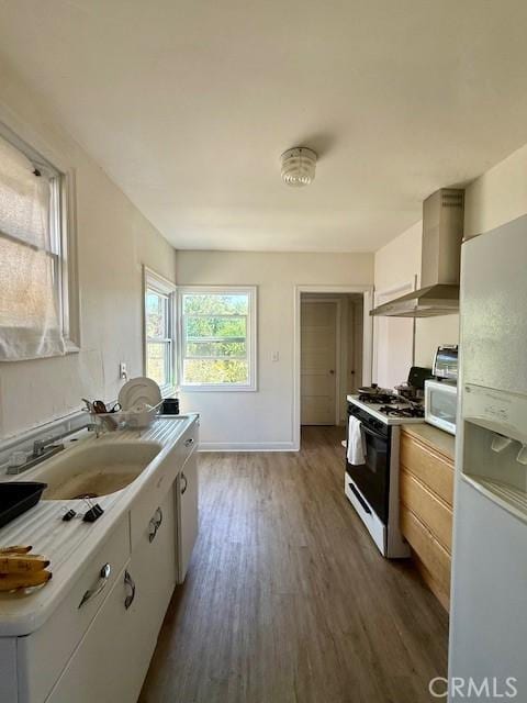 4544 Tulip Ave, Oakland, CA 94619 - kitchen featuring white appliances, wall chimney exhaust hood, dark wood-type flooring, and light countertops