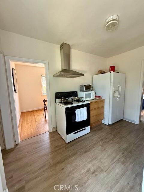 4544 Tulip Ave, Oakland, CA 94619 - kitchen with white appliances, wall chimney range hood, and light wood-style floors