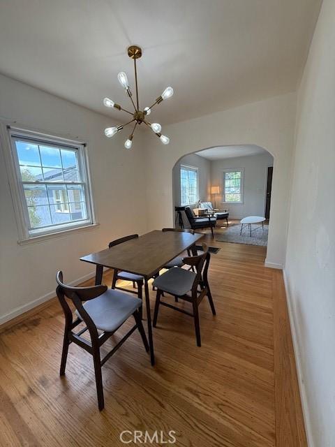4544 Tulip Ave, Oakland, CA 94619 - dining space with arched walkways, a chandelier, and wood finished floors