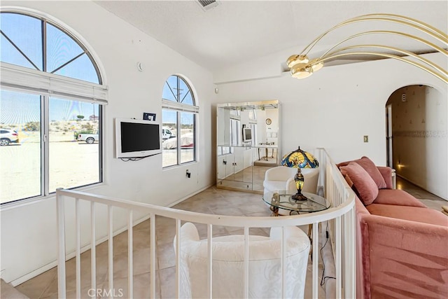 6333 Carodean Rd Unit 29, Palms, CA 92277 - tiled living area featuring vaulted ceiling and arched walkways