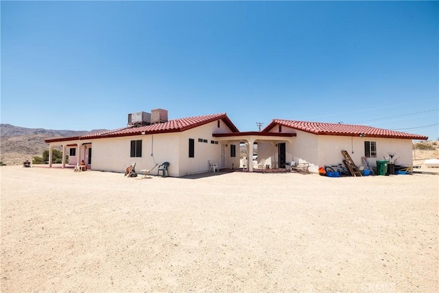 6333 Carodean Rd Unit 29, Palms, CA 92277 - back of house featuring stucco siding, a chimney, and a mountain view