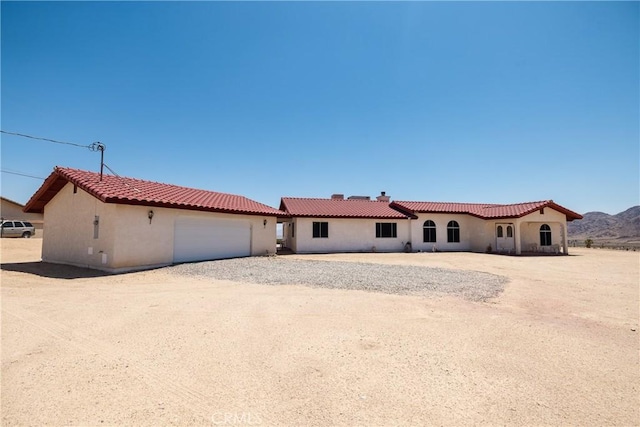6333 Carodean Rd Unit 29, Palms, CA 92277 - mediterranean / spanish home with stucco siding, an attached garage, a tiled roof, and driveway