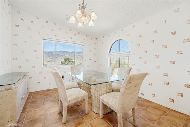 6333 Carodean Rd Unit 29, Palms, CA 92277 - dining area featuring wallpapered walls, a chandelier, light tile patterned floors, and a textured ceiling